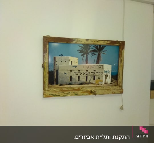 תמונה תלויה על קיר עם מסגרת עץ